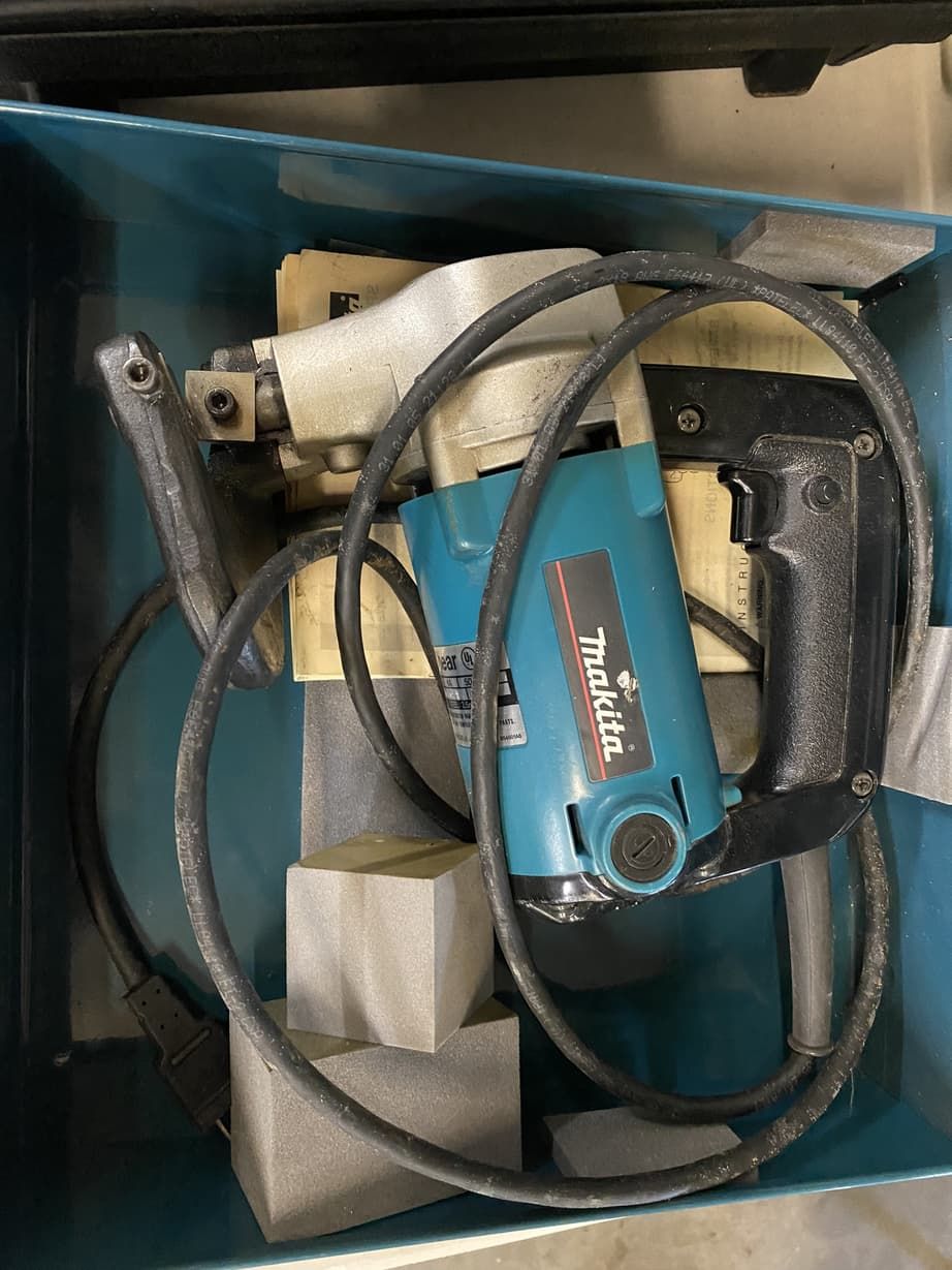 A makita drill is sitting in a box on a table.