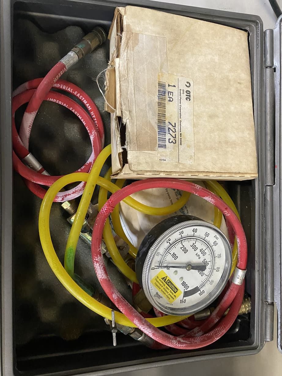 A box with a pressure gauge and hose in it