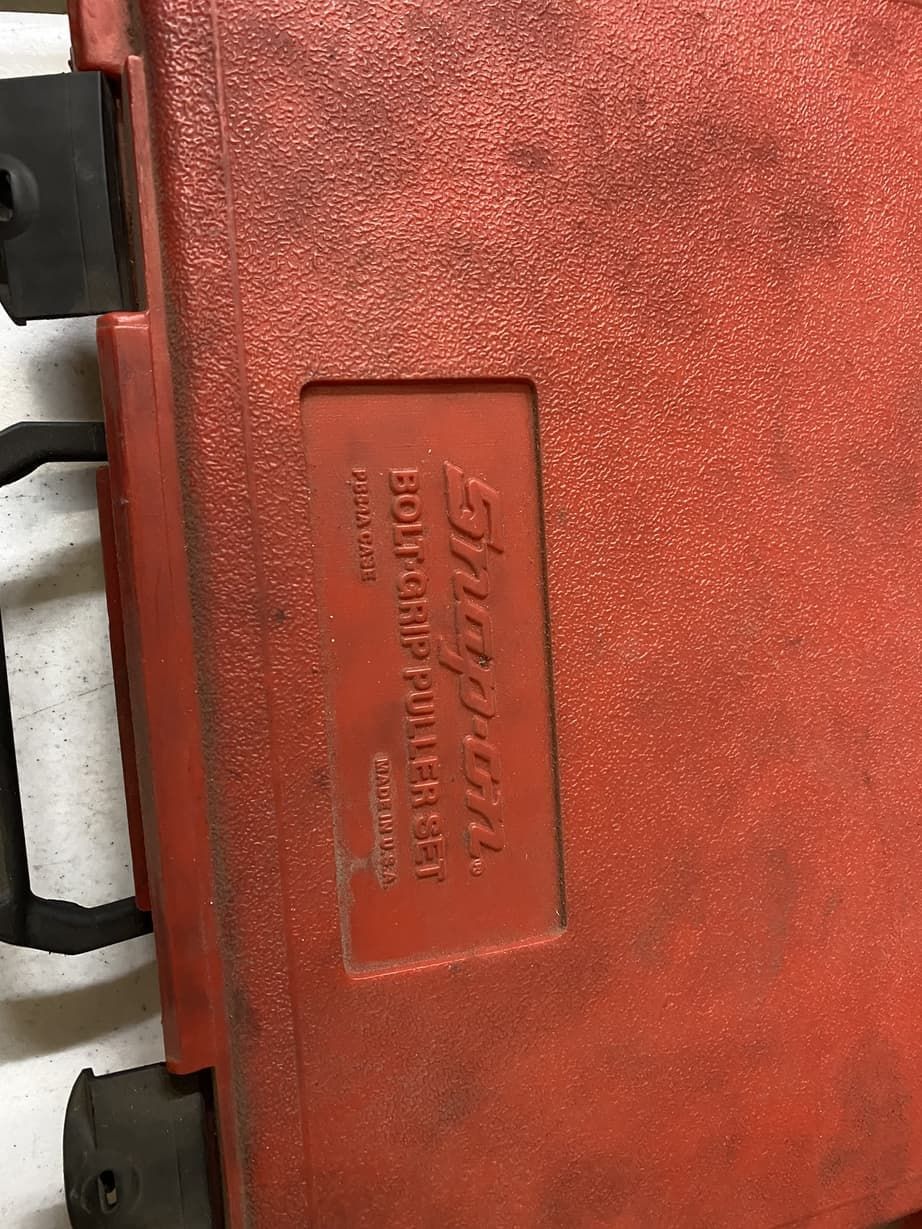 A red snap on toolbox is sitting on a table.