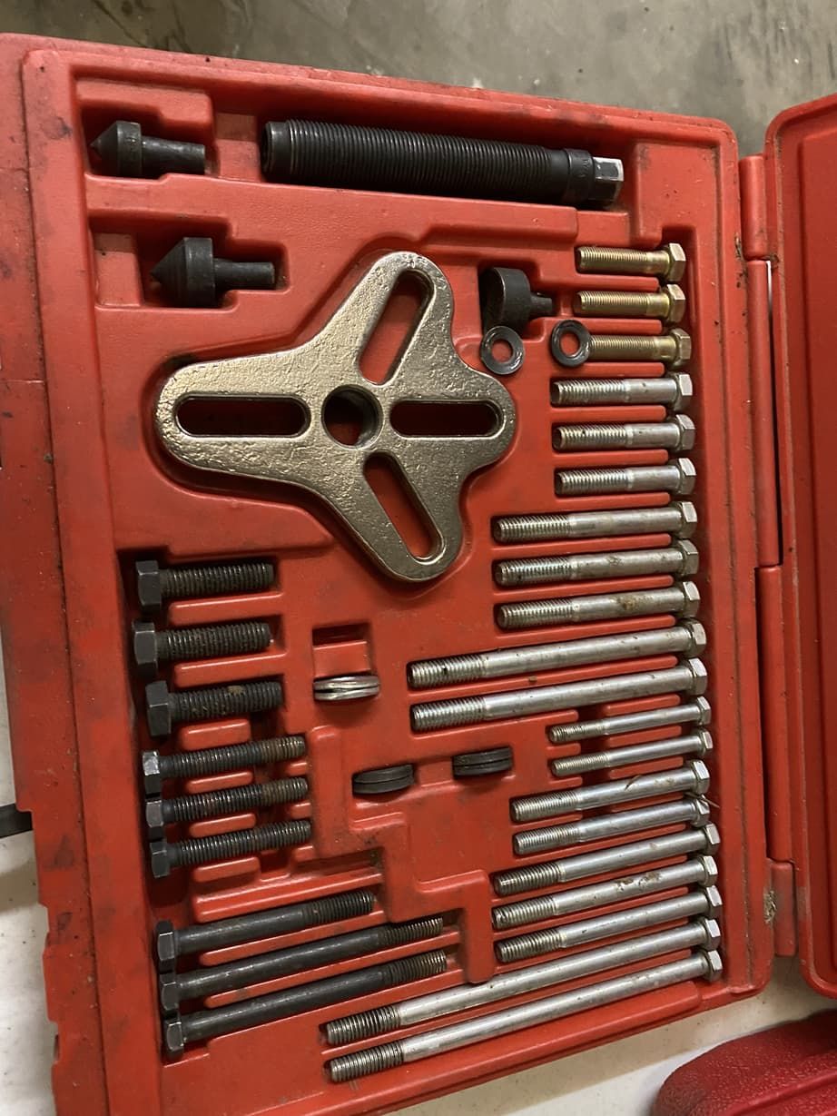 A red box filled with tools including a puller