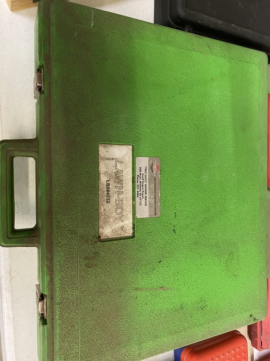 A green plastic case with a handle is sitting on a table.