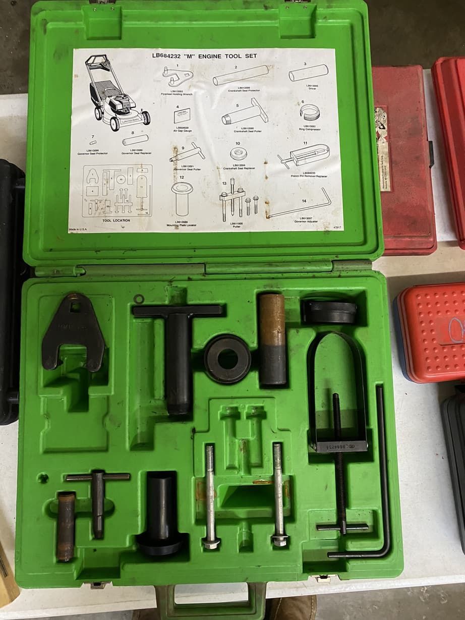 A green box filled with tools is sitting on a table.