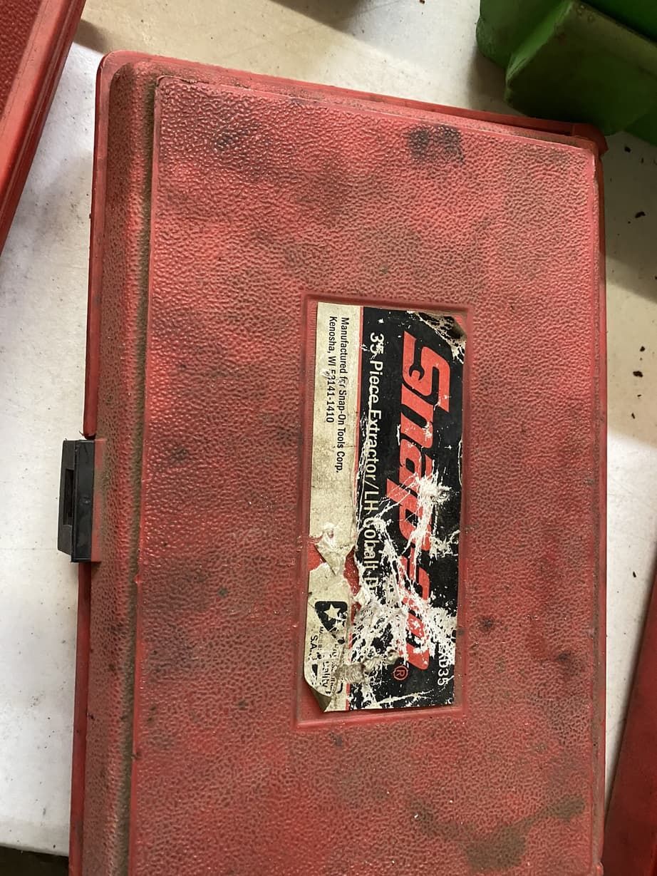 A red snap on toolbox is sitting on a table.