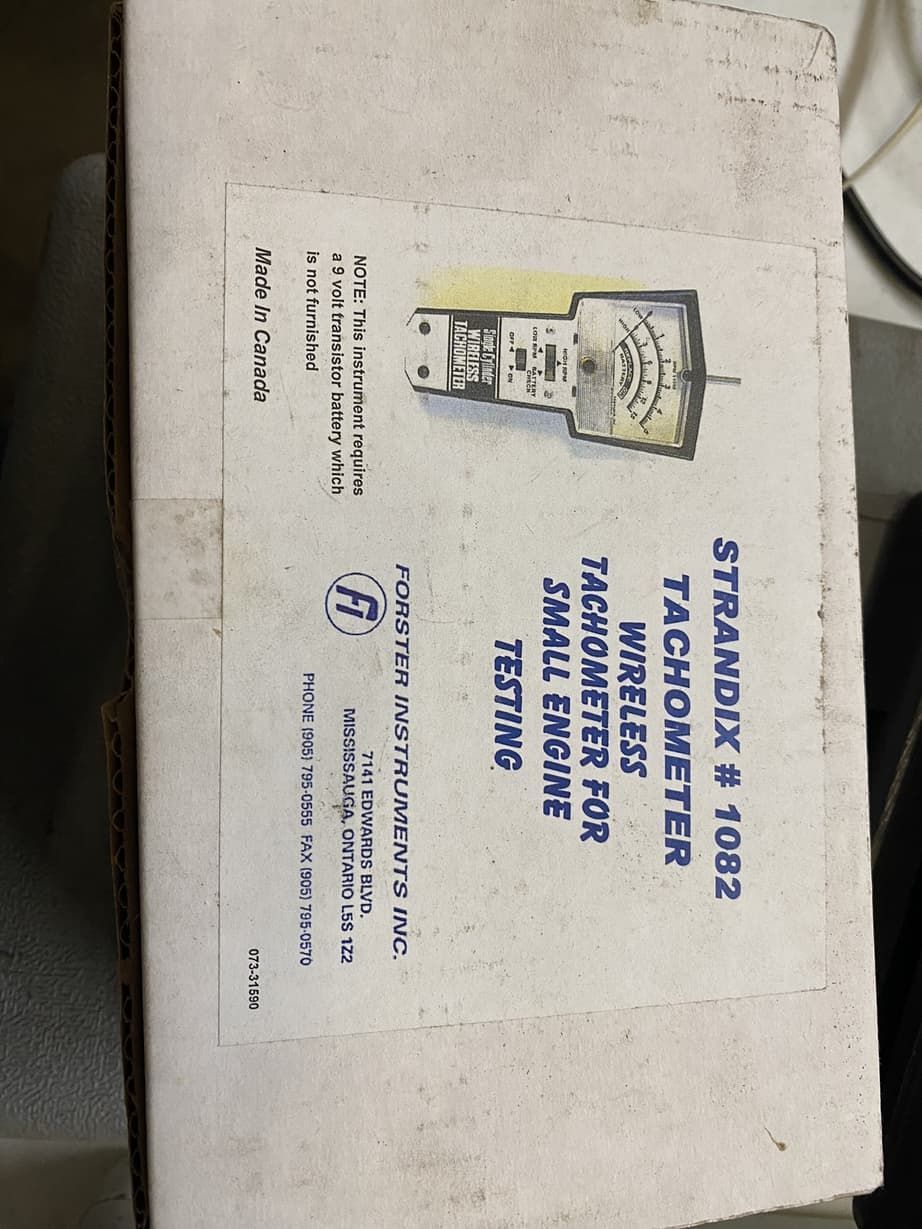 A small engine tachometer is in a white box