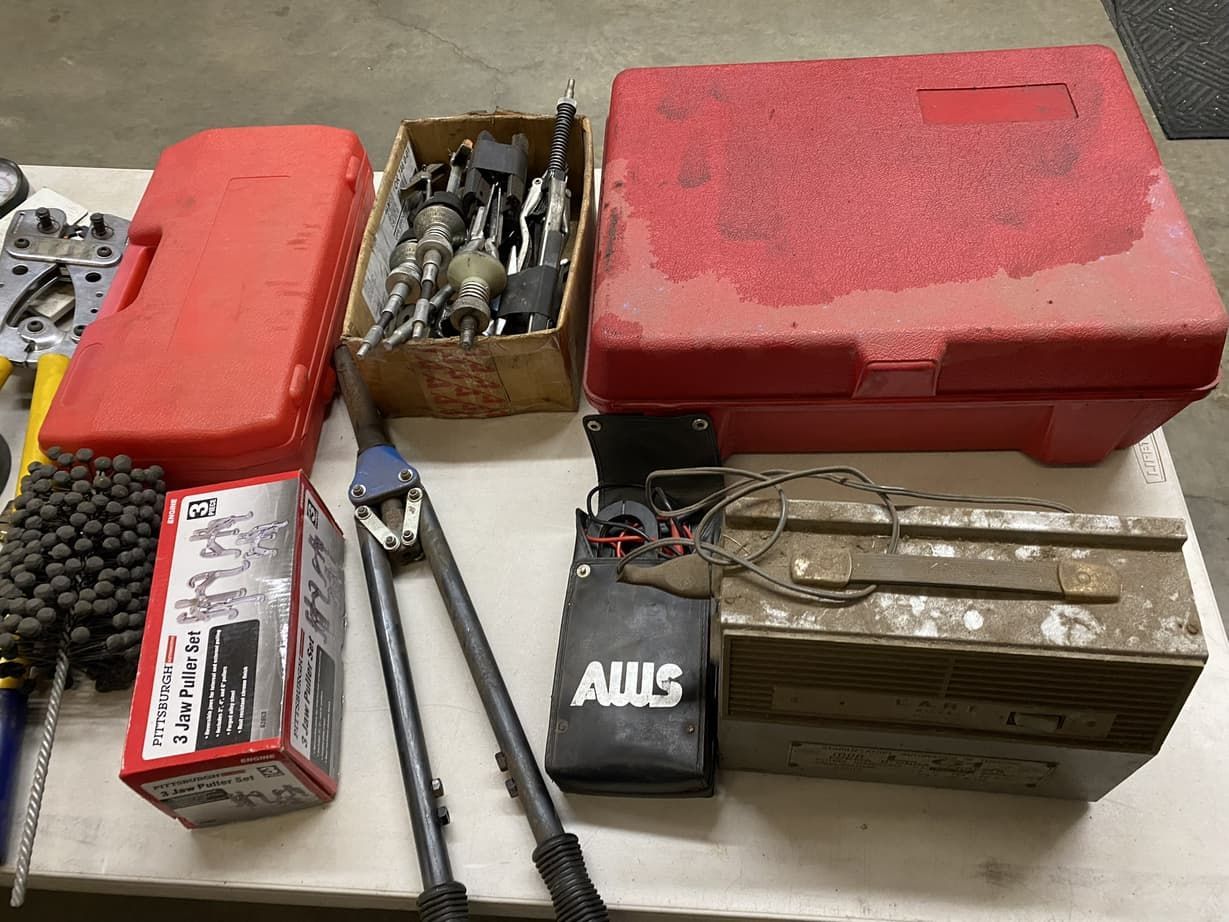 A bunch of tools are sitting on a table including a box that says auls