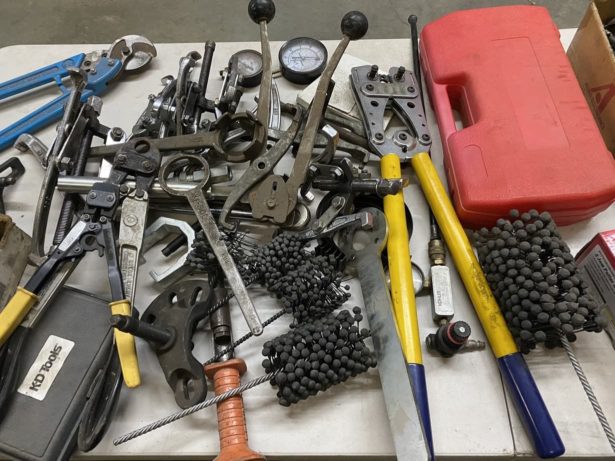 A bunch of tools on a table including a red case