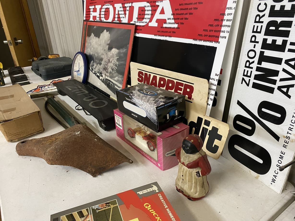 A table with a lot of items on it including a sign that says honda