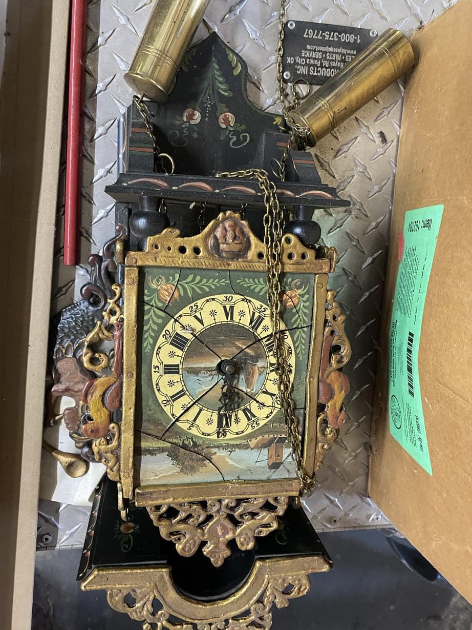 A clock is sitting on top of a cardboard box.