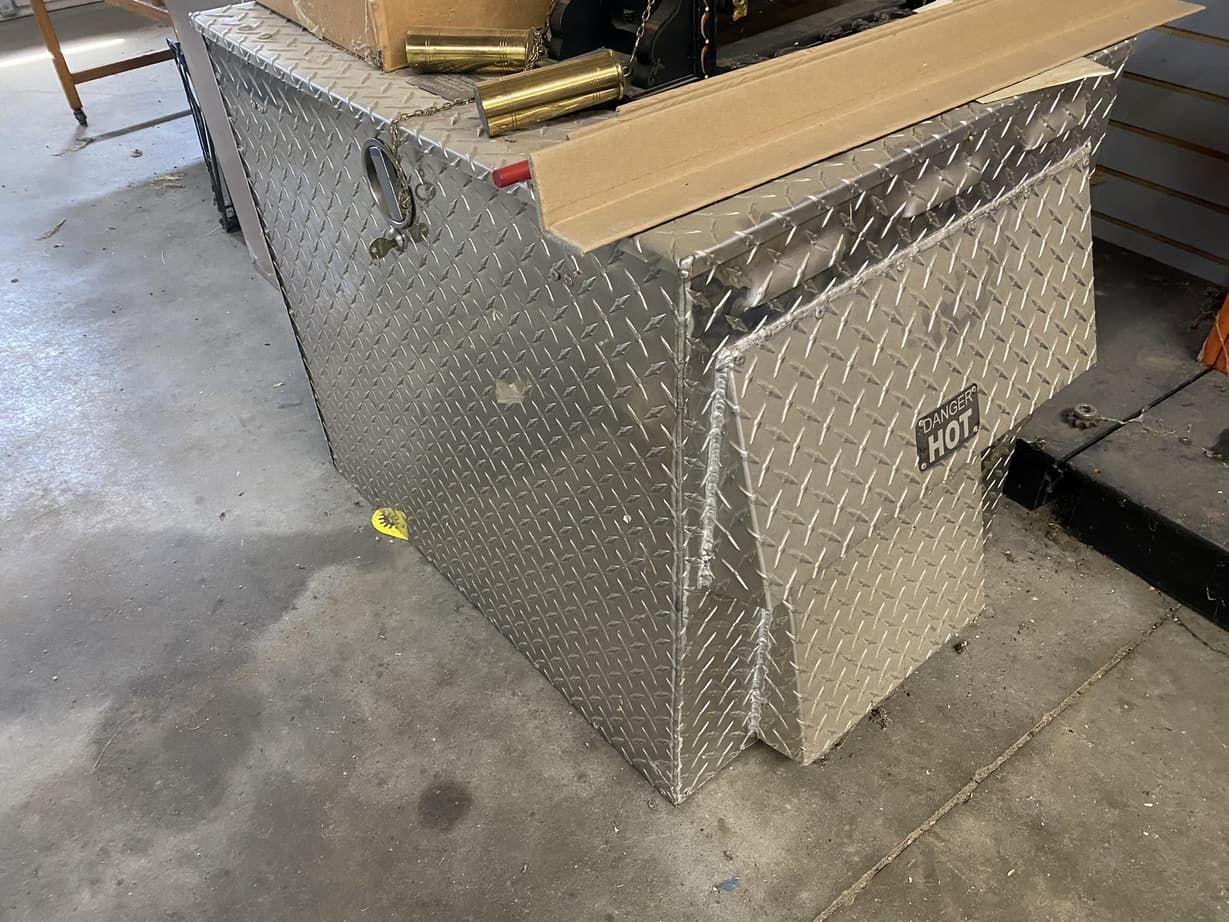 A large aluminum box is sitting on top of a concrete floor.