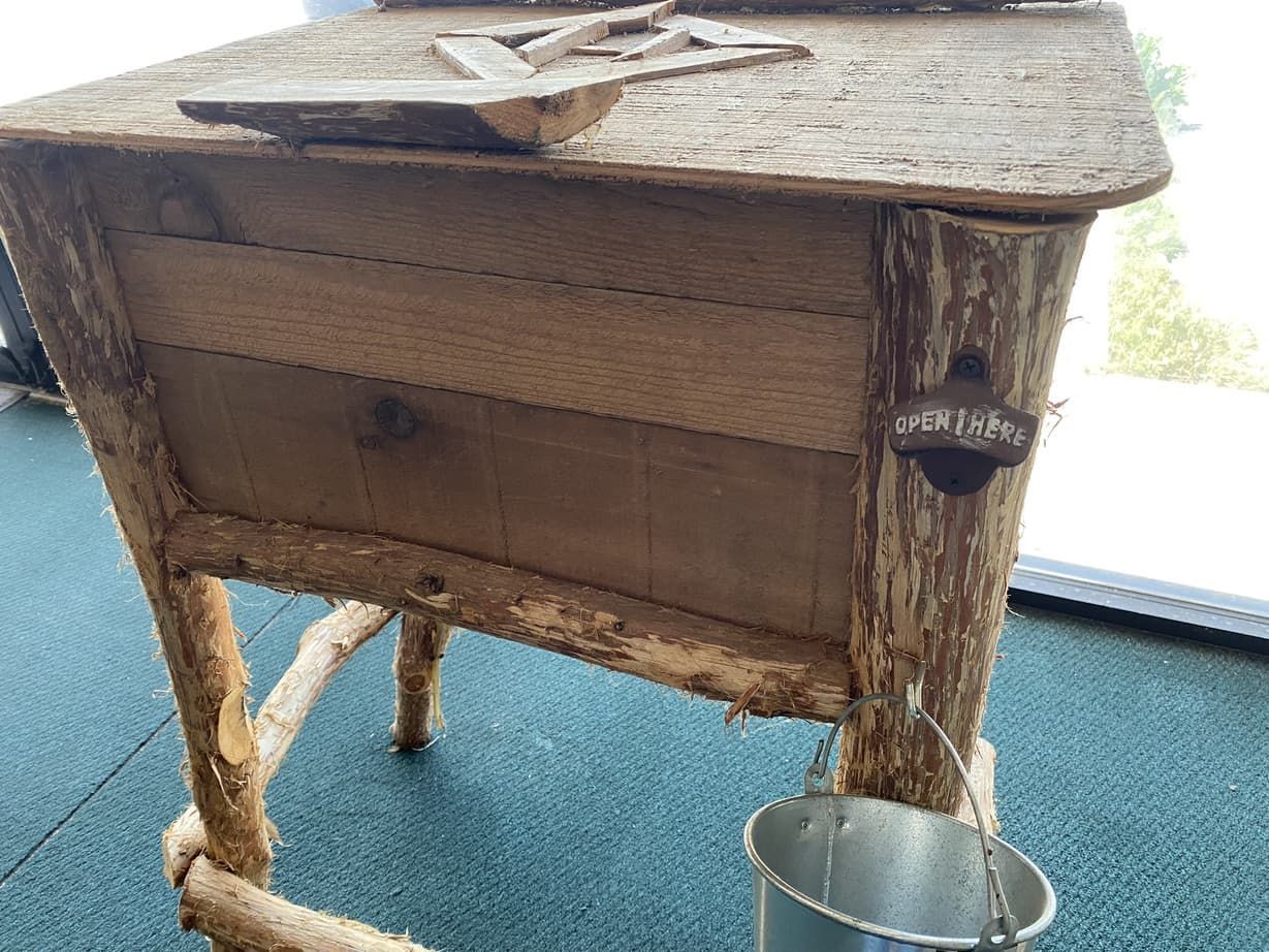 A wooden table with a bucket attached to it.