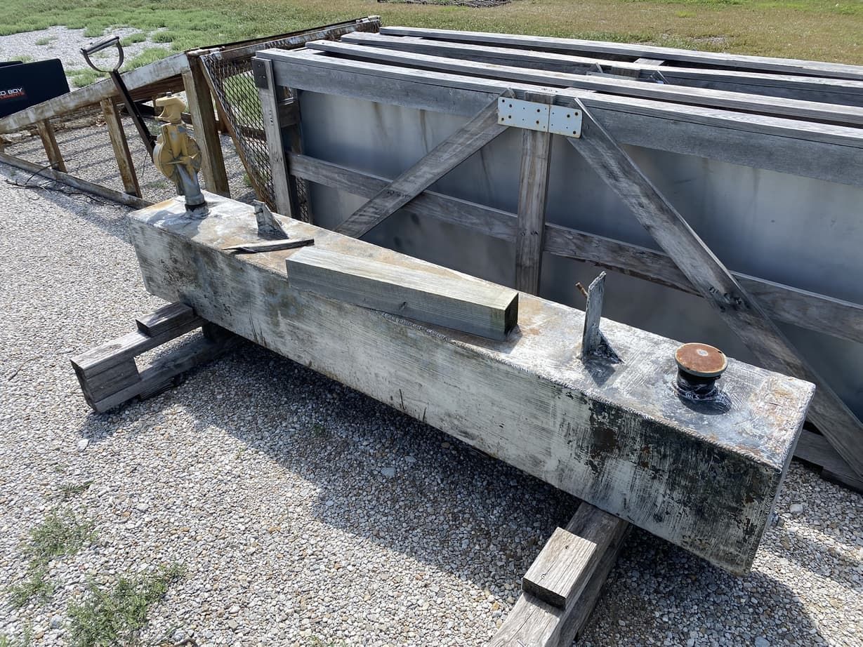 A large concrete beam is sitting on top of a gravel road.