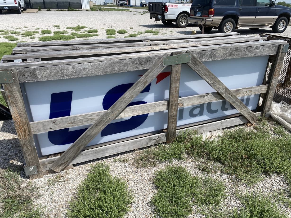 A large sign is sitting in a wooden crate.