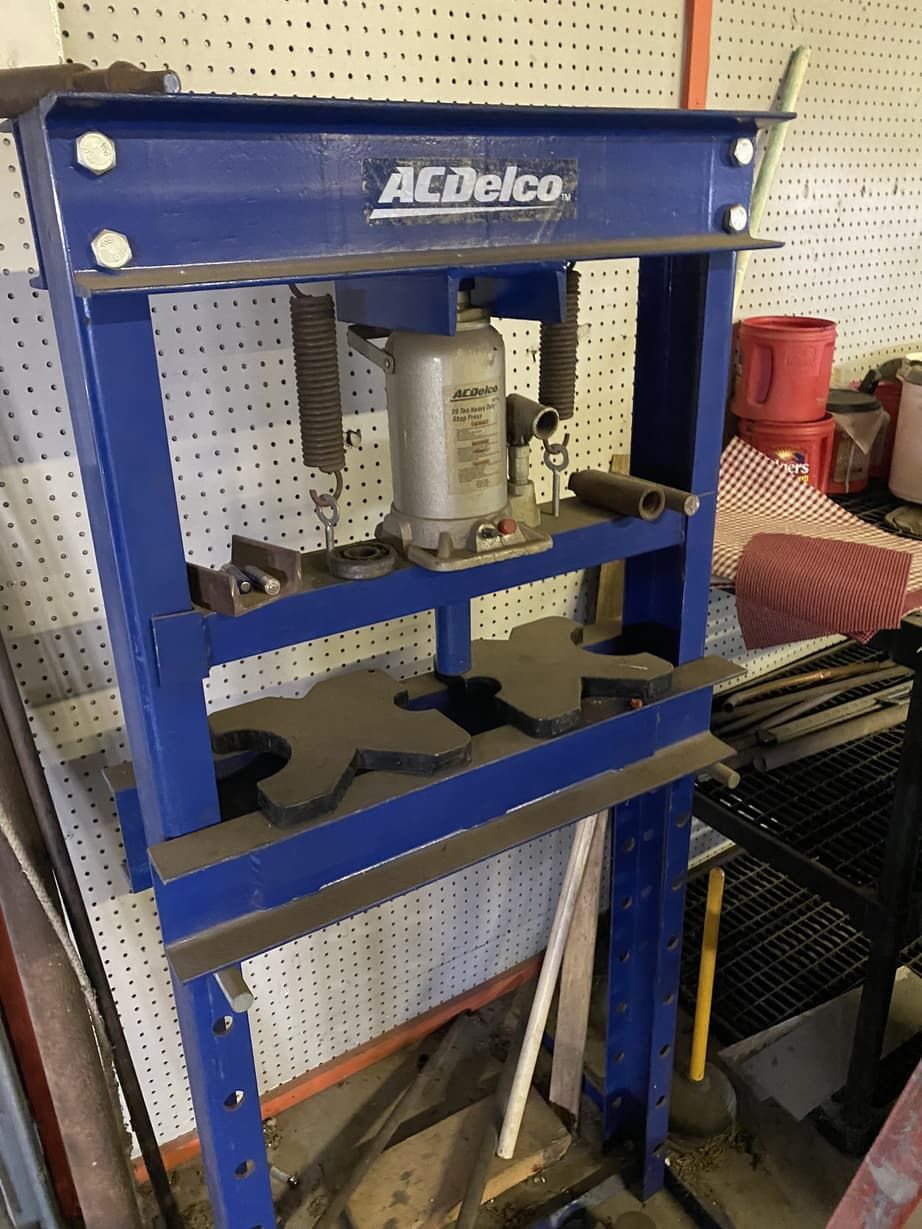 A blue acdelco press is sitting in a garage.