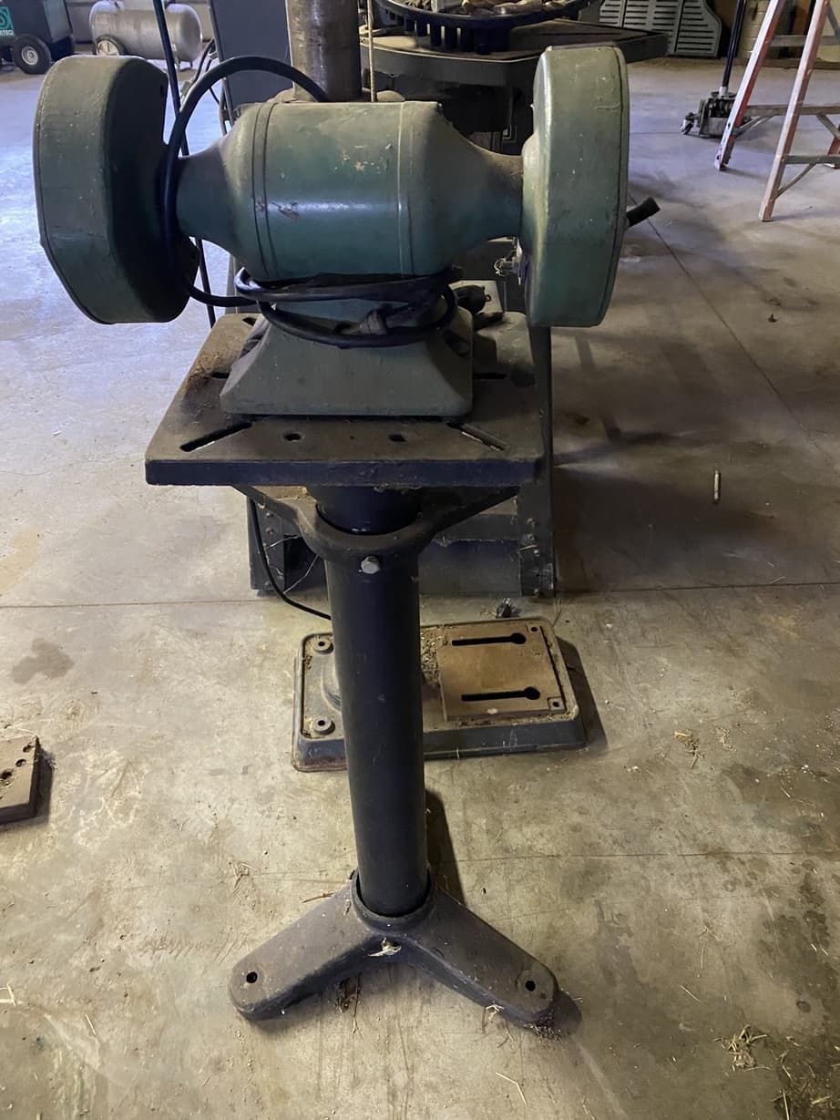 A grinder is sitting on top of a table in a garage.