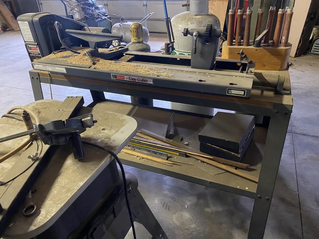 A workbench with a lathe and a saw on it