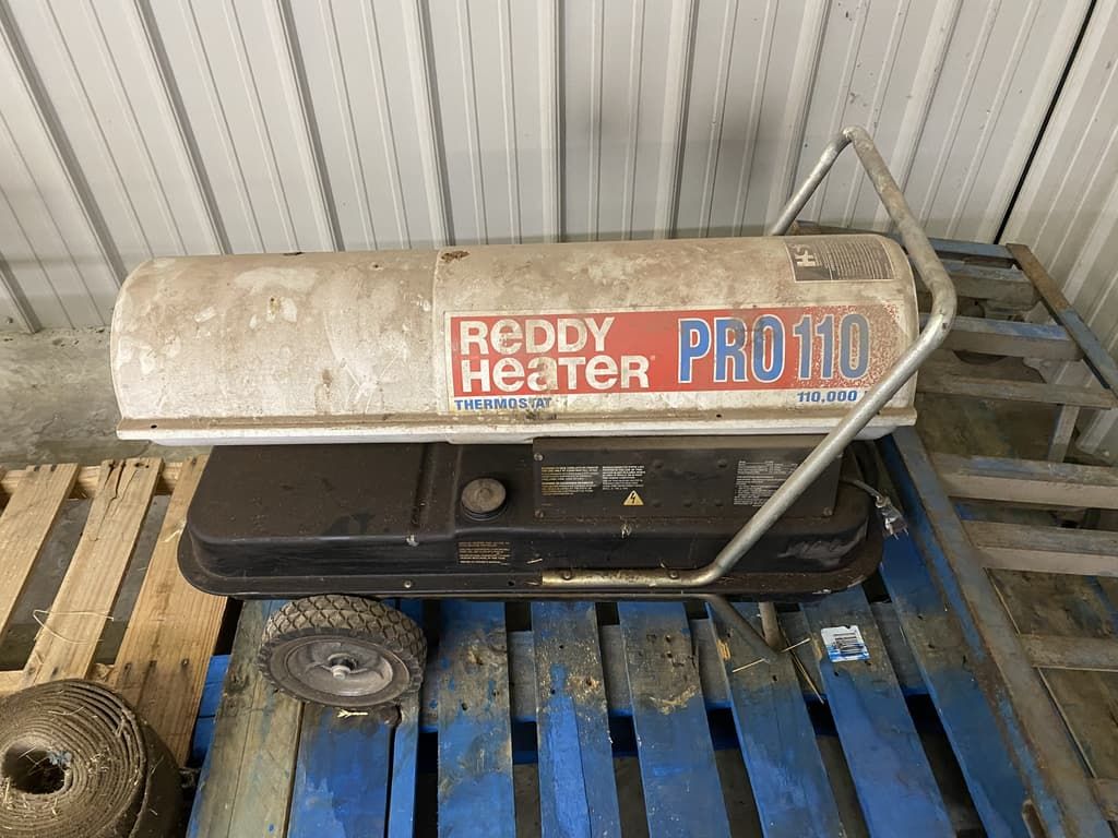 A reddy heater is sitting on top of a wooden pallet.