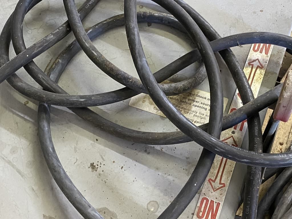 A bunch of wires are laying on a concrete floor
