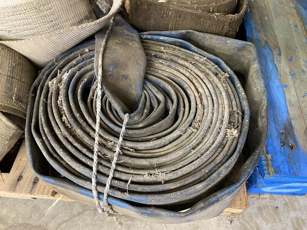 A roll of hose is sitting on top of a wooden pallet.