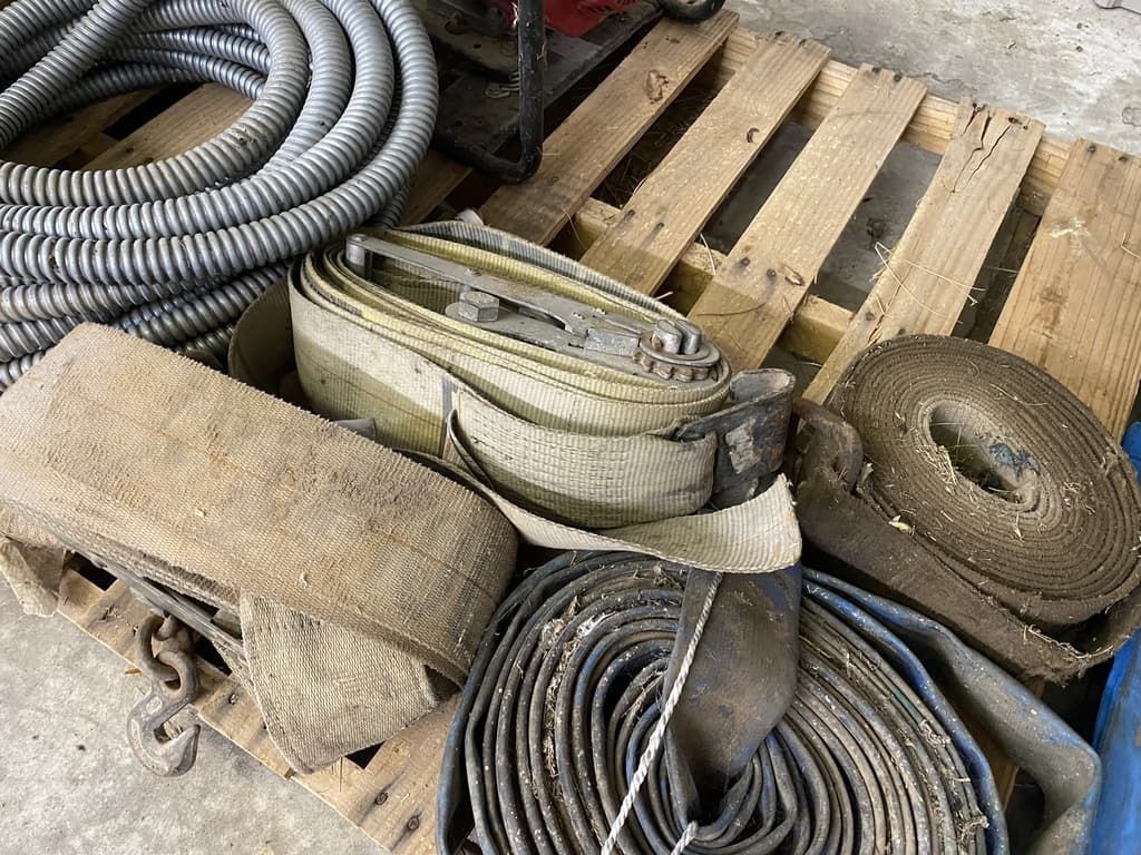 A bunch of hose and chains are sitting on top of a wooden pallet.