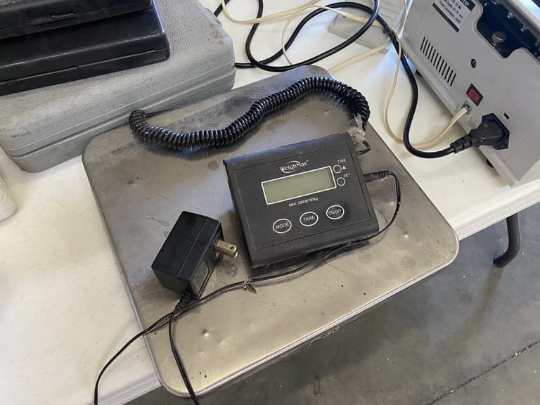 A digital scale is sitting on top of a metal tray on a table.