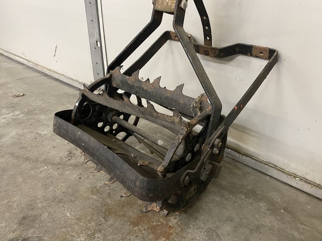 A lawn mower is sitting on the ground in front of a garage door.