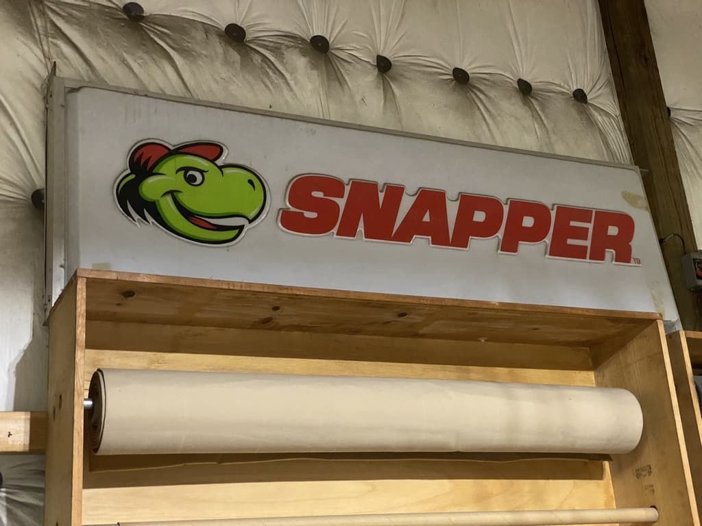 A sign that says snapper with a dinosaur on it