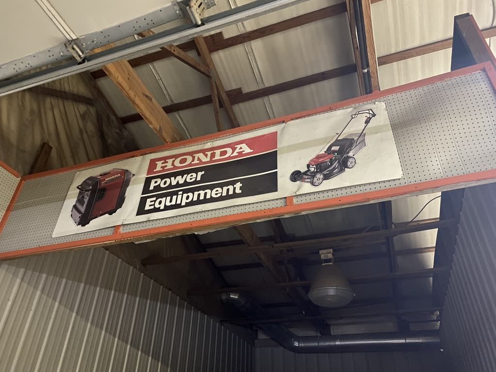 A honda power equipment sign hangs from the ceiling of a building.