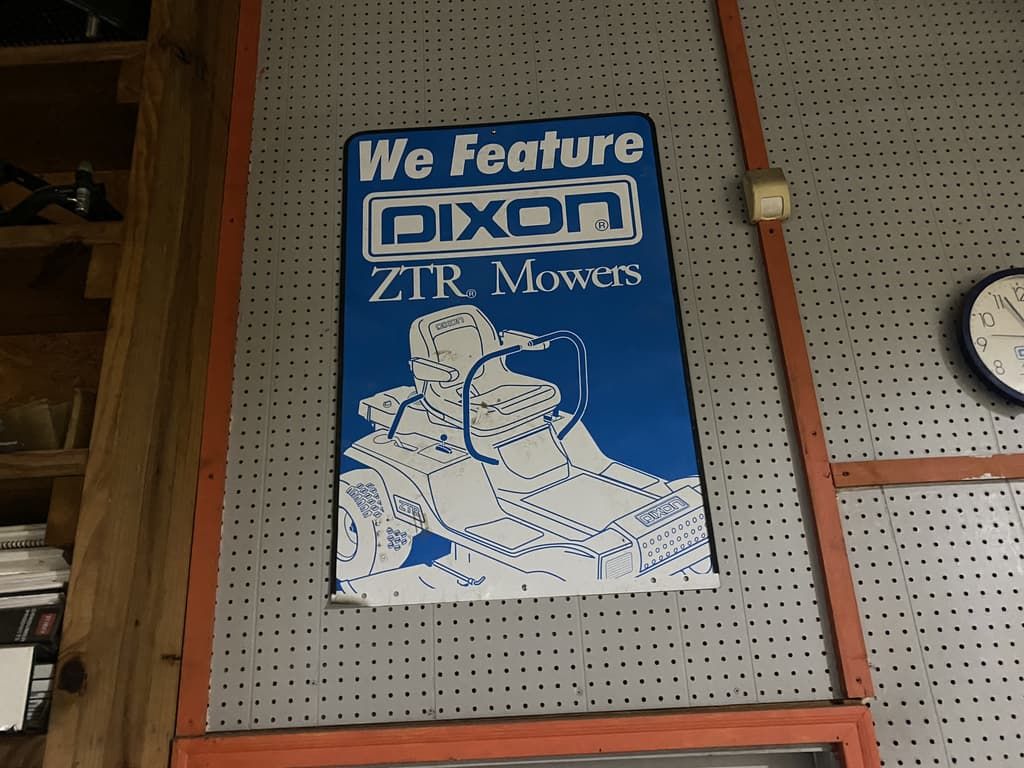 A sign on a wall that says we feature dixon zir mowers