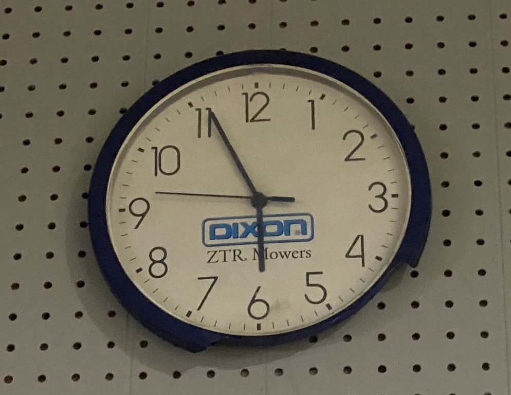 A dixon clock is hanging on a wall