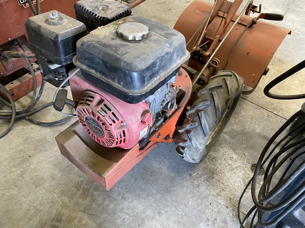 A red engine is sitting on top of a red tractor.