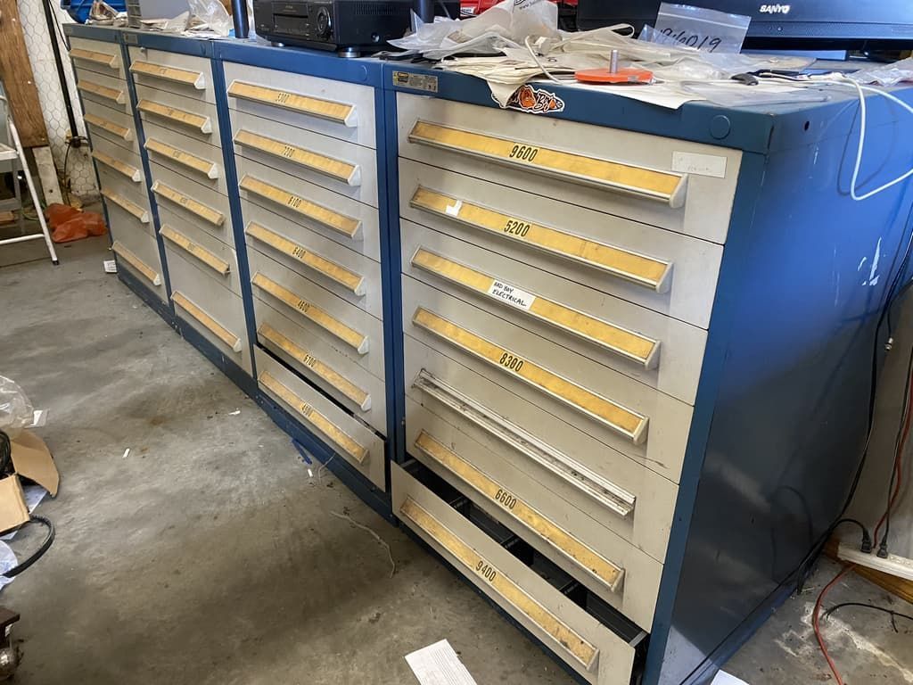 A row of drawers with yellow handles are lined up in a room.