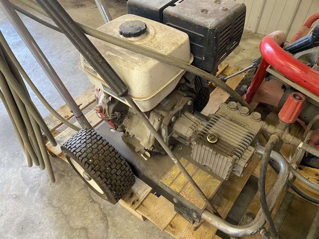 A pressure washer is sitting on top of a wooden pallet.