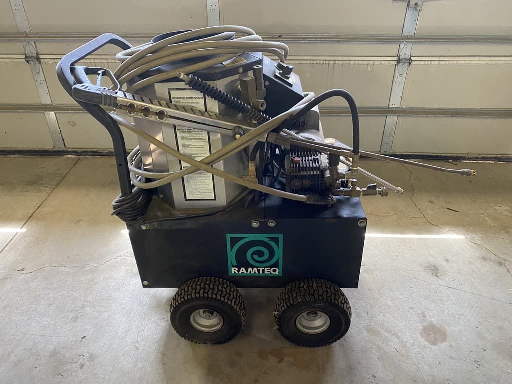 A machine with wheels is sitting in front of a garage door.