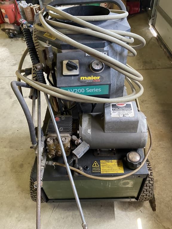 A high pressure washer is sitting on the floor in a garage.