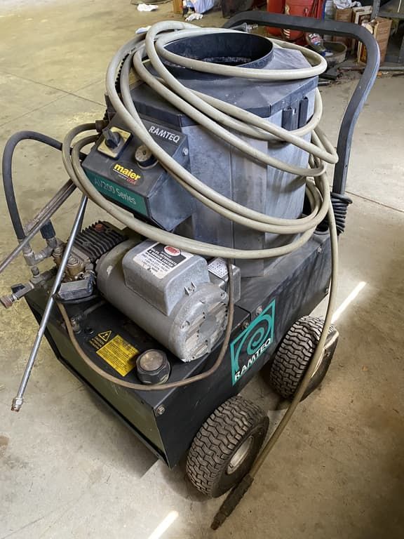 A machine with a lot of wires attached to it is sitting on the floor.
