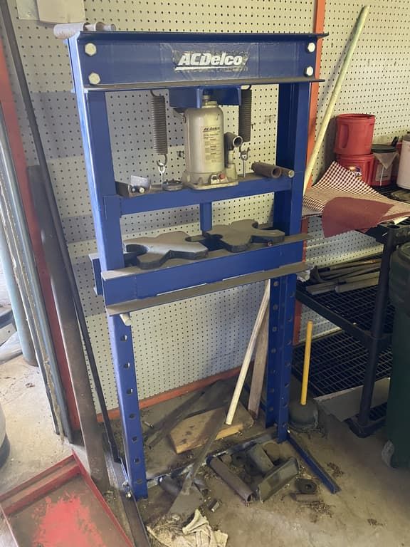 A blue acdelco press is sitting in a garage.