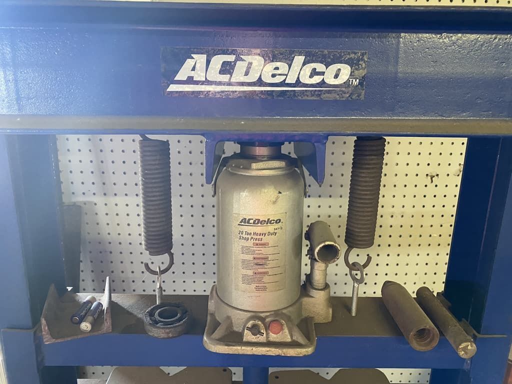 An acdelco hydraulic jack is sitting on top of a blue workbench.