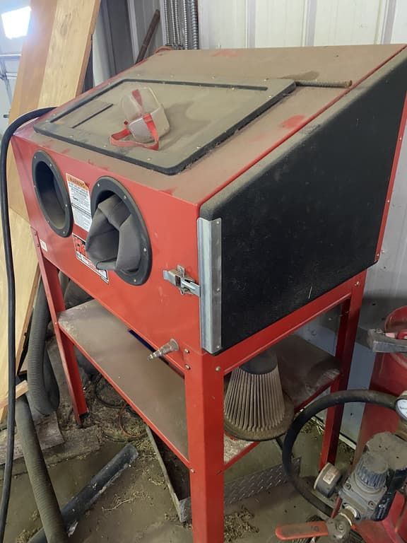 A red machine is sitting on top of a wooden table.