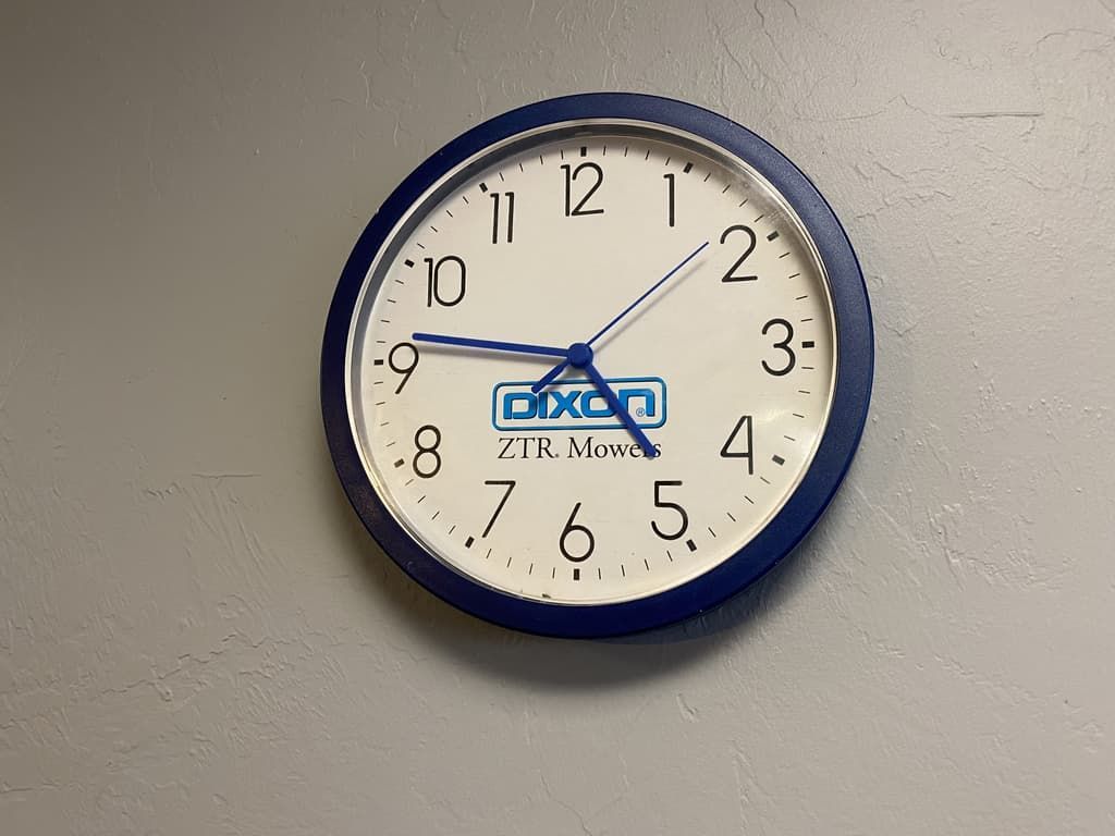 A blue and white clock on a wall that says dixen on it