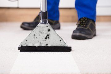 Picture of an upclose view of a carpet cleaning machine in action.