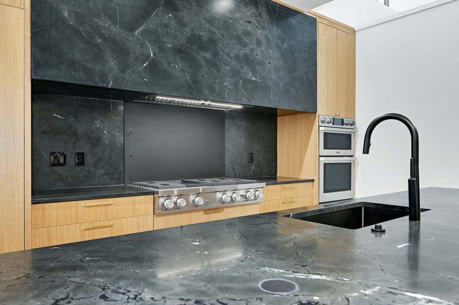 A kitchen with a sink , stove , and oven.