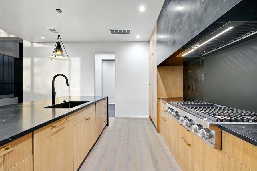 A kitchen with wooden cabinets and a stove top oven.