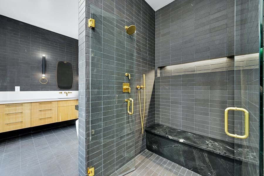 A bathroom with a walk in shower and a bench.