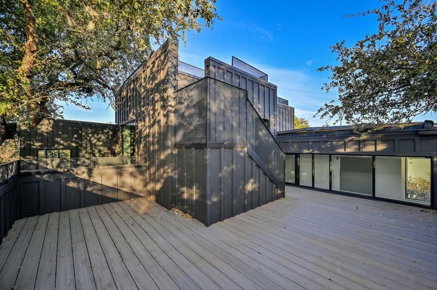 A large deck with stairs leading up to the roof of a house.