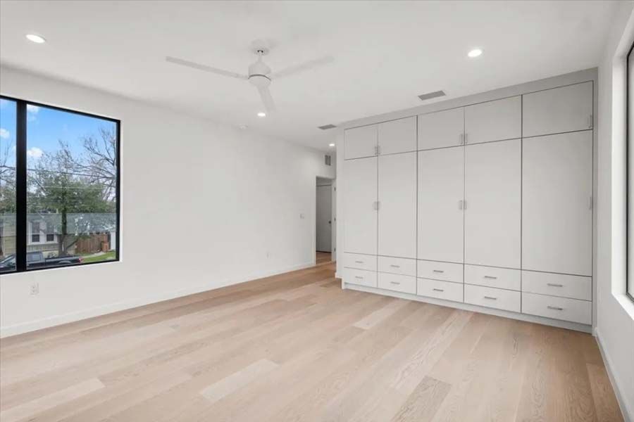 There is a ceiling fan in the room and a large window.