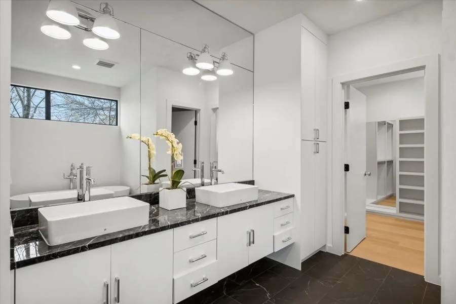 A bathroom with two sinks and a large mirror.