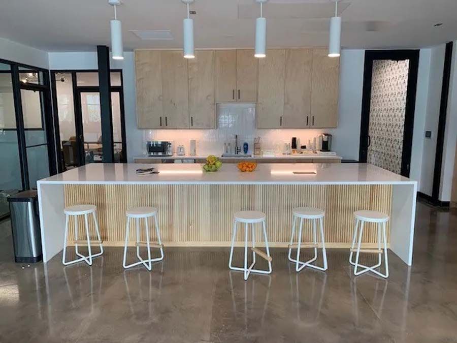 A kitchen with a long island and stools