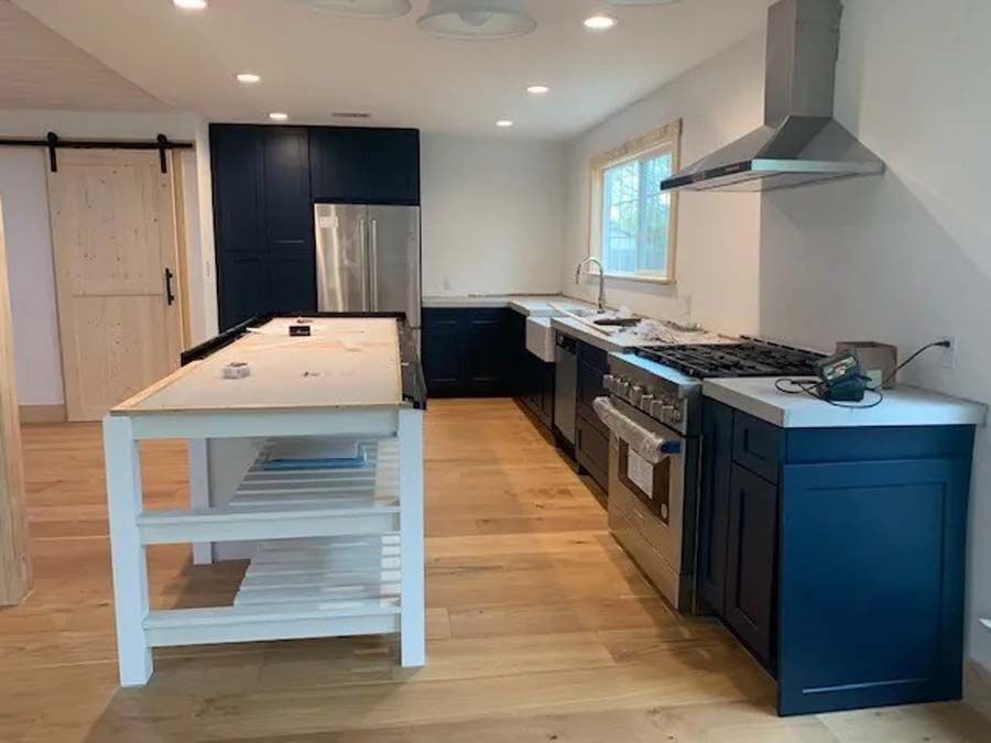 A kitchen with stainless steel appliances and blue cabinets