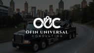 Black tow truck on a road with city skyline in the background, OUC logo on the truck.