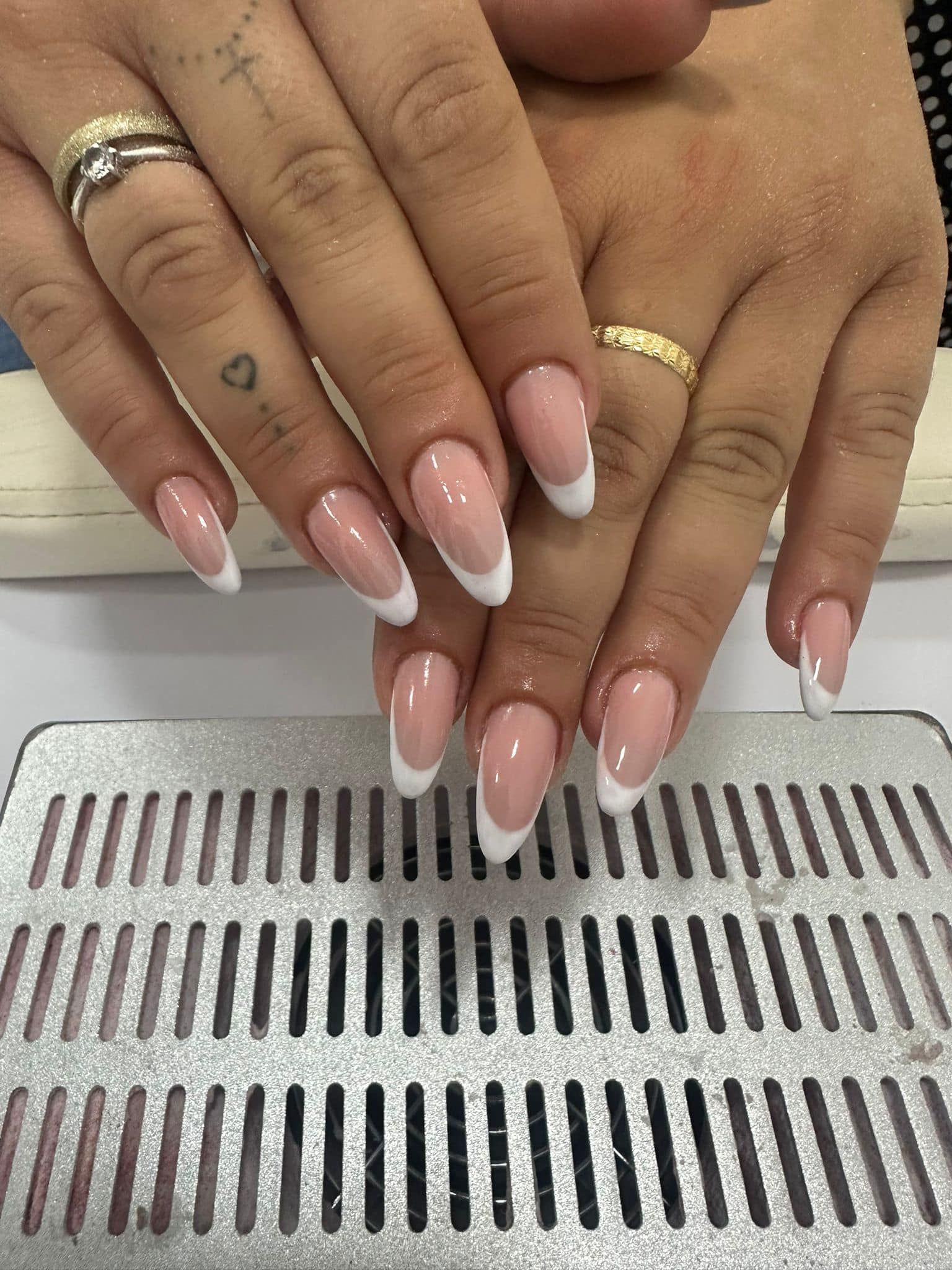 Un primo piano delle unghie di una donna con una manicure francese